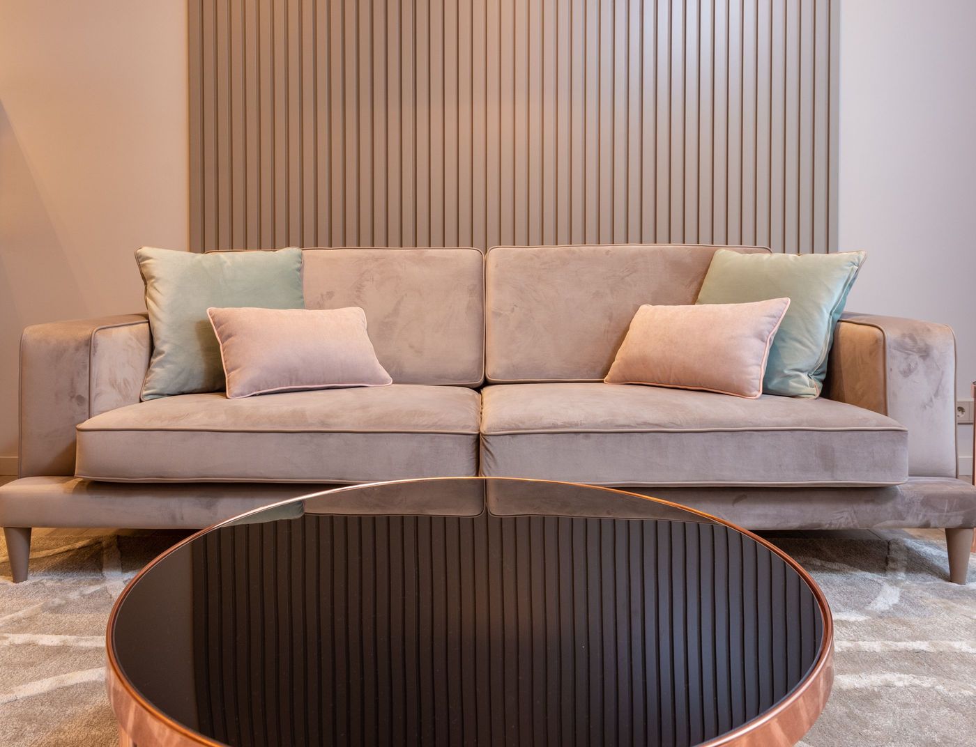 A clean, fresh living room with a sofa and rug